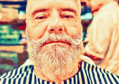 Barber with a beard and haircut at IbraDan Creative, showcasing professional grooming services.