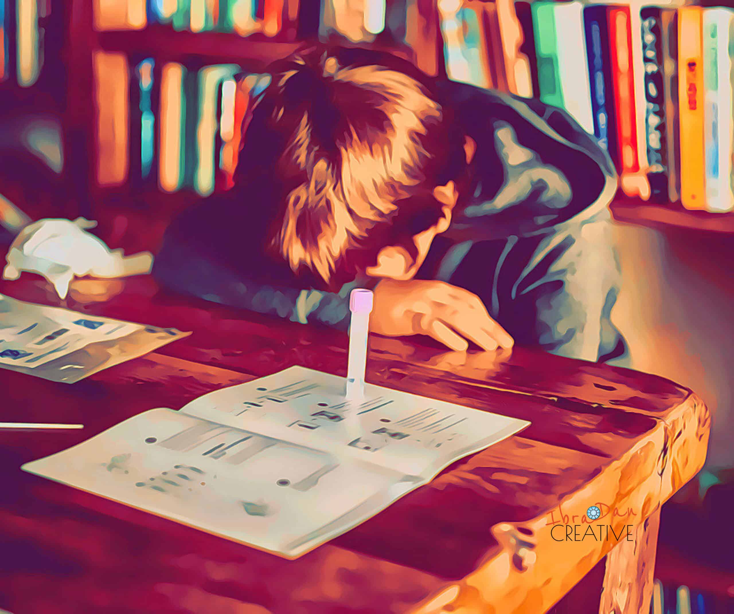Person studying with pen and papers at a wooden desk in a library.